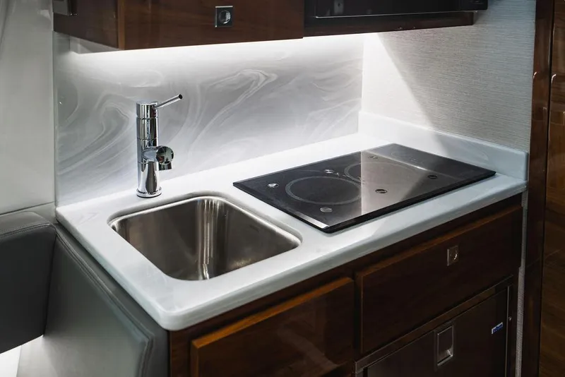 Slide: The Image of 2023 Valhalla V-46 boat kitchen with sink and stovetop, modern design. - 17