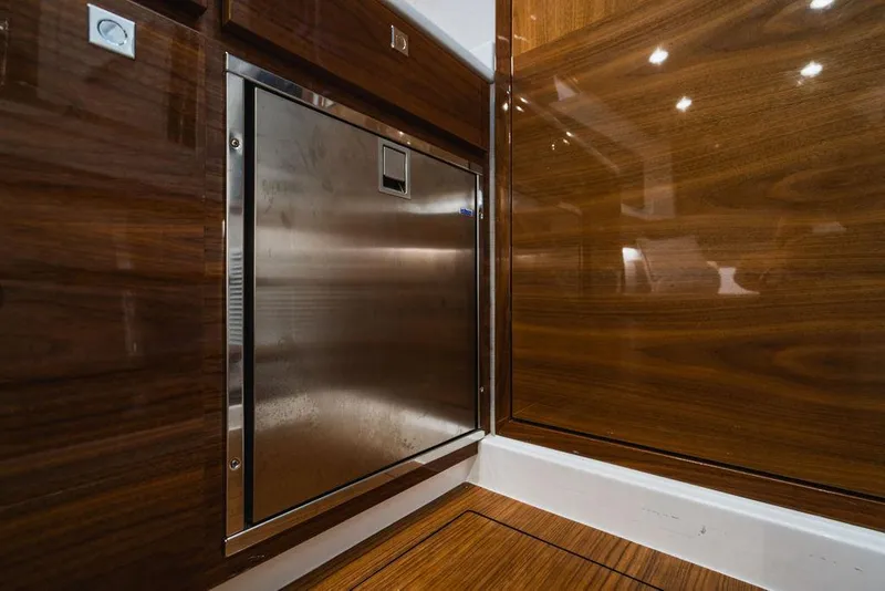 Slide: The Image of 2023 Valhalla V-46 interior with stainless steel appliance and polished wood finish. - 18