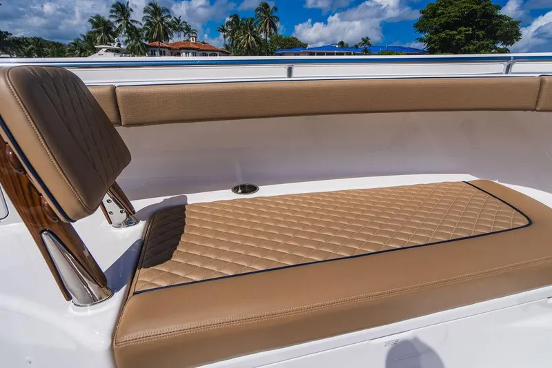 Slide: The Image of 2023 Valhalla V-46 boat with tan quilted seating, tropical backdrop. - 22