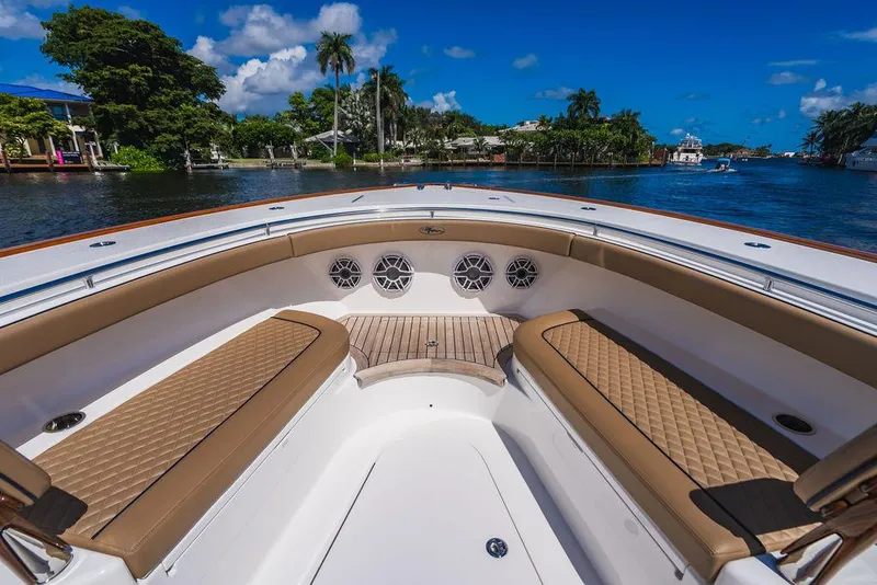 Slide: The Image of 2023 Valhalla Boatworks V-46 bow seating area with tan cushions on a sunny day. - 23