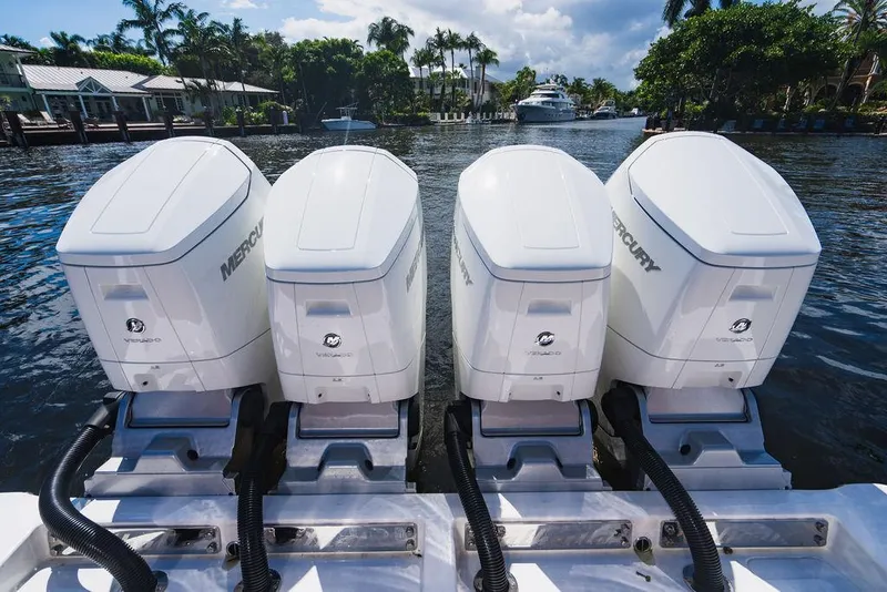 Slide: The Image of Four Mercury outboard engines on a 2023 Valhalla Boatworks V-46, docked by a scenic waterfront. - 31