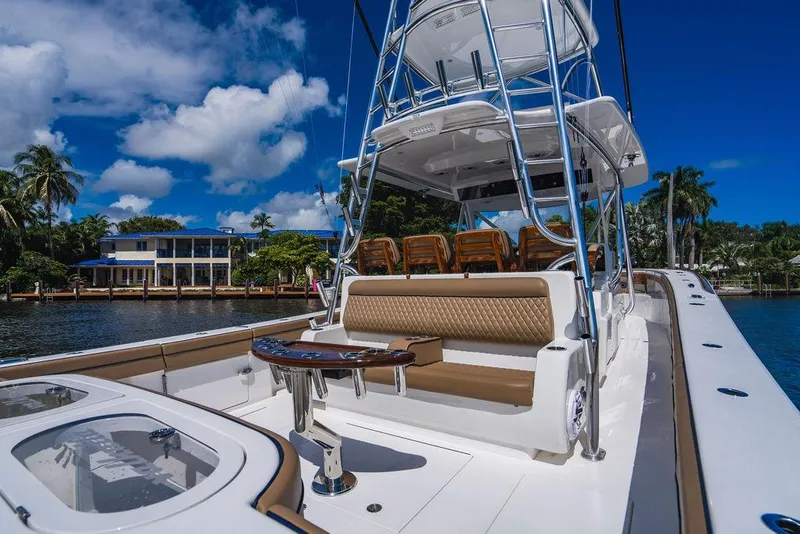 Slide: The Image of 2023 Valhalla Boatworks V-46 luxury yacht with elegant seating and tower, docked by palm trees. - 33