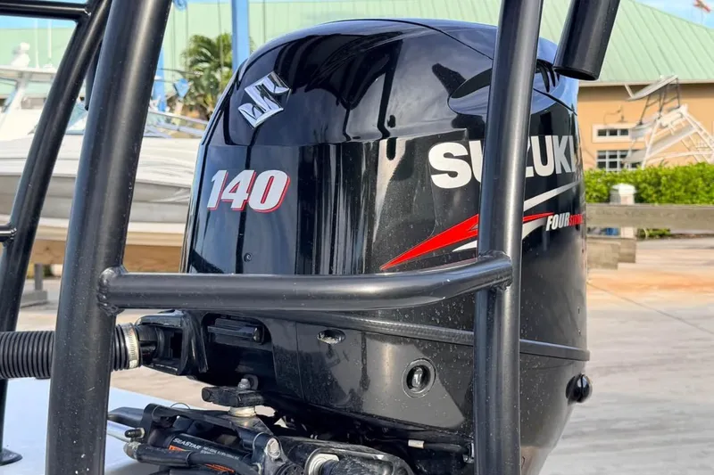 Slide: The Image of 2014 East Cape Vantage VHP with Suzuki 140 outboard motor, docked near boats. - 15