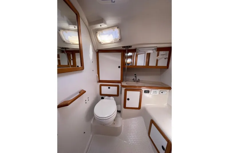 Slide: The Image of Interior of 1999 Catalina 36 MkII yacht bathroom with sink, toilet, and storage cabinets. - 30