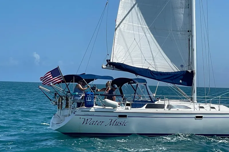 Slide: The Image of Sailing on a 1999 Catalina 36 MkII, "Water Music," with American flag in open sea. - 8