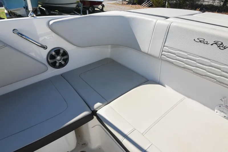 Slide: The Image of Interior seating of 2021 Sea Ray SPX 210 boat, featuring white upholstery and speaker. - 16
