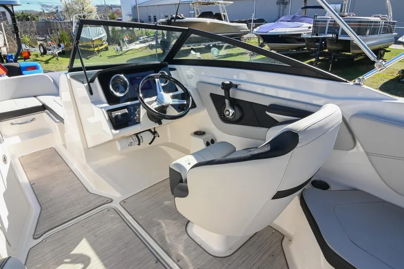 Slide: The Image of 2021 Sea Ray SPX 210 boat interior with steering wheel and seating. - 25