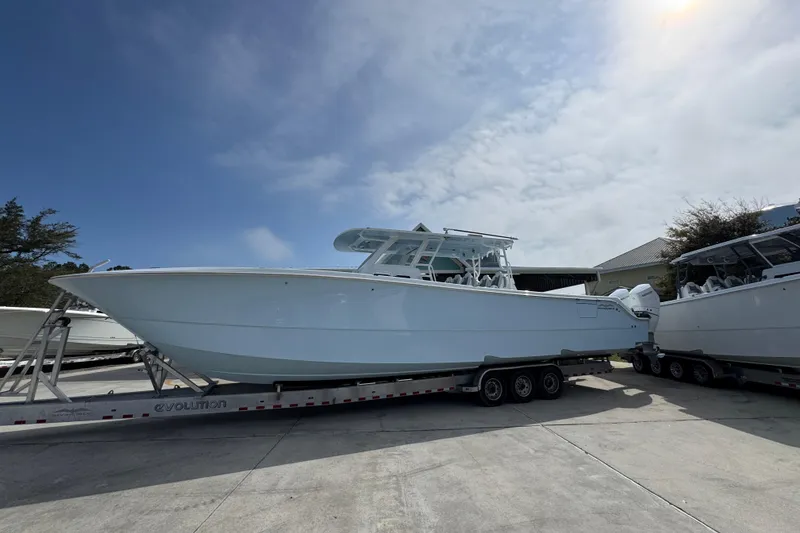 The Image of 2026 Invincible 46 Catamaran on trailer under a partly cloudy sky. - 1