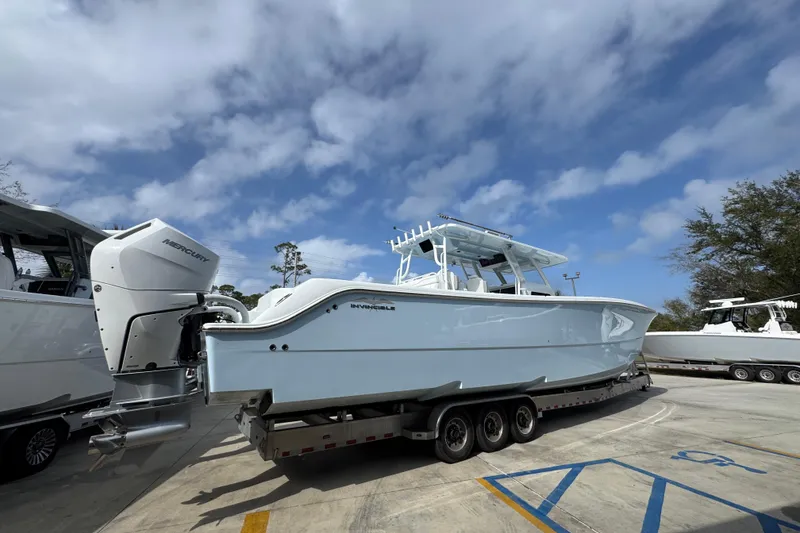 Slide: The Image of 2026 Invincible 46 Catamaran on trailer under cloudy sky. - 10