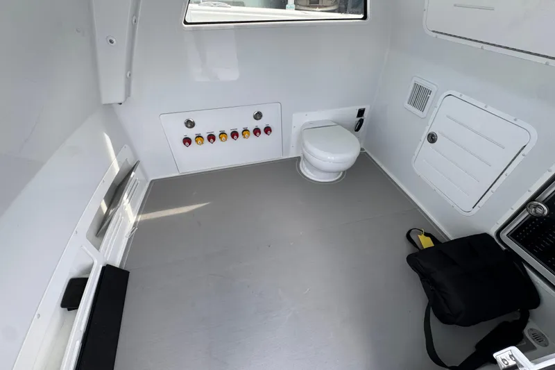 Slide: The Image of Interior of 2026 Invincible 46 Catamaran featuring a compact bathroom with a toilet. - 23