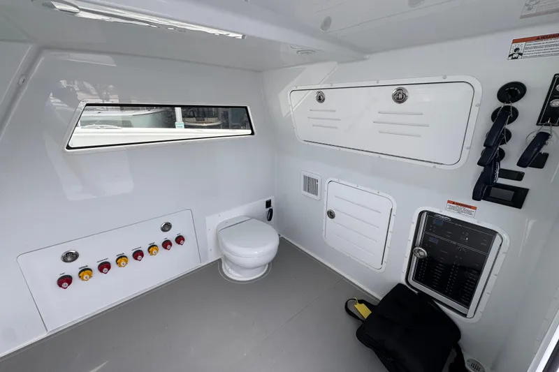 Slide: The Image of Interior of 2026 Invincible 46 Catamaran featuring control panel and marine toilet. - 24