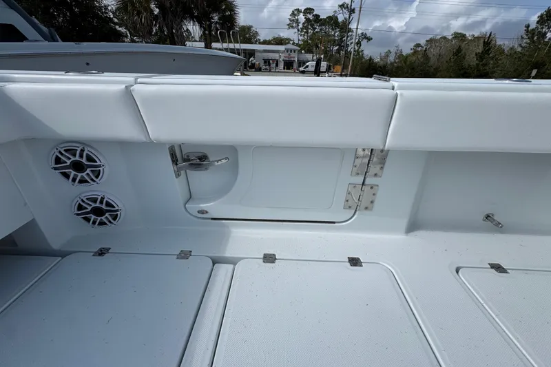 Slide: The Image of Interior view of 2026 Invincible 46 Catamaran, featuring sleek white seating and built-in speakers. - 38