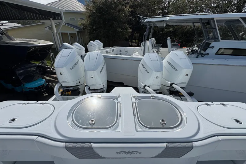 Slide: The Image of 2026 Invincible 46 Catamaran with multiple Mercury outboard engines, docked outdoors. - 41