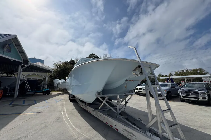 Slide: The Image of 2026 Invincible 46 Catamaran on trailer, parked outdoors under cloudy sky. - 6
