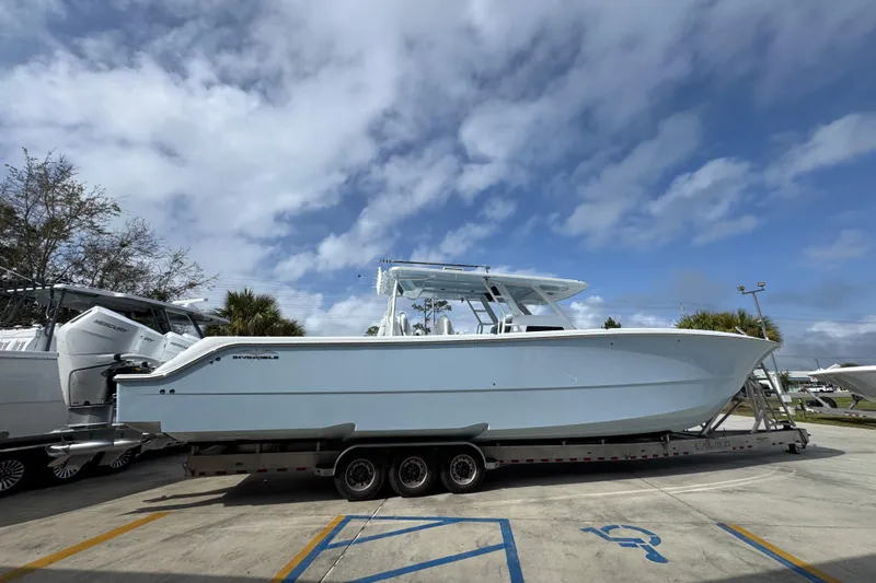 Slide: The Image of 2026 Invincible 46 Catamaran on trailer under cloudy sky. - 9