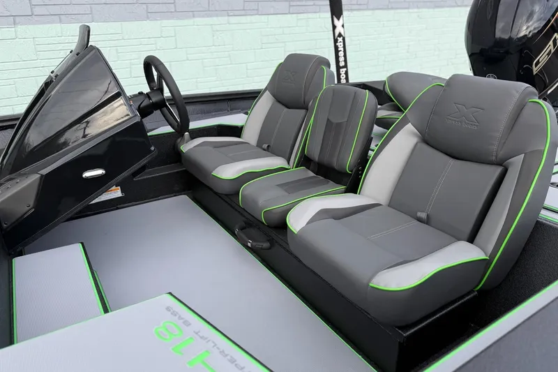 Slide: The Image of 2026 Xpress H18 boat interior with gray and green seats, modern dashboard, and steering wheel. - 4