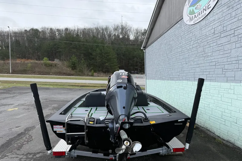 Slide: The Image of 2026 Xpress H18 boat parked outside a marine shop, rear view. - 7