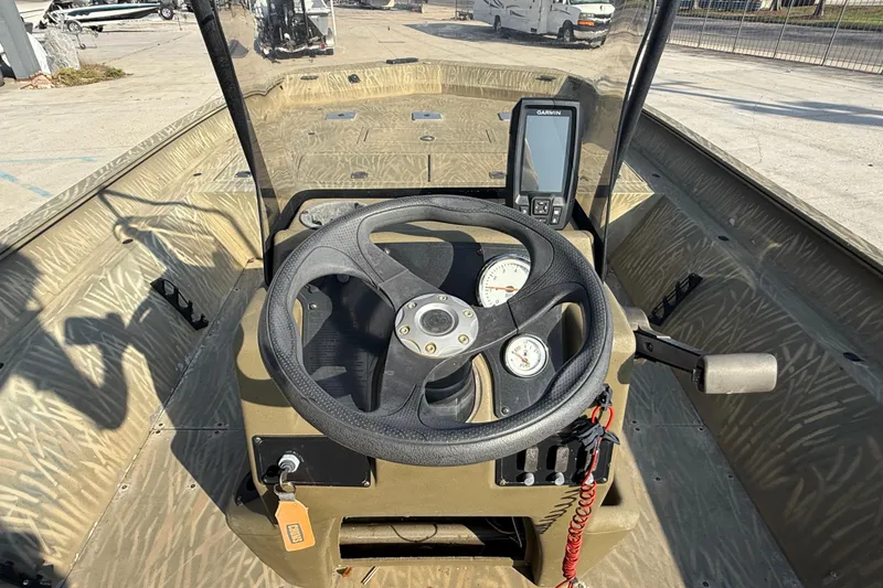 Slide: The Image of 2018 Tracker Grizzly 2072 CC boat dashboard with steering wheel and Garmin device. - 11
