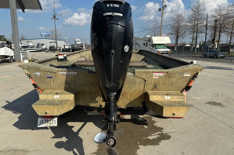 Slide: The Image of 2018 Tracker Grizzly 2072 CC boat with outboard motor, parked outdoors. - 5
