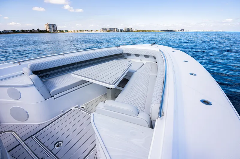 Slide: The Image of 2024 HCB 53 Suenos luxury boat interior with seating and table on calm water. - 13