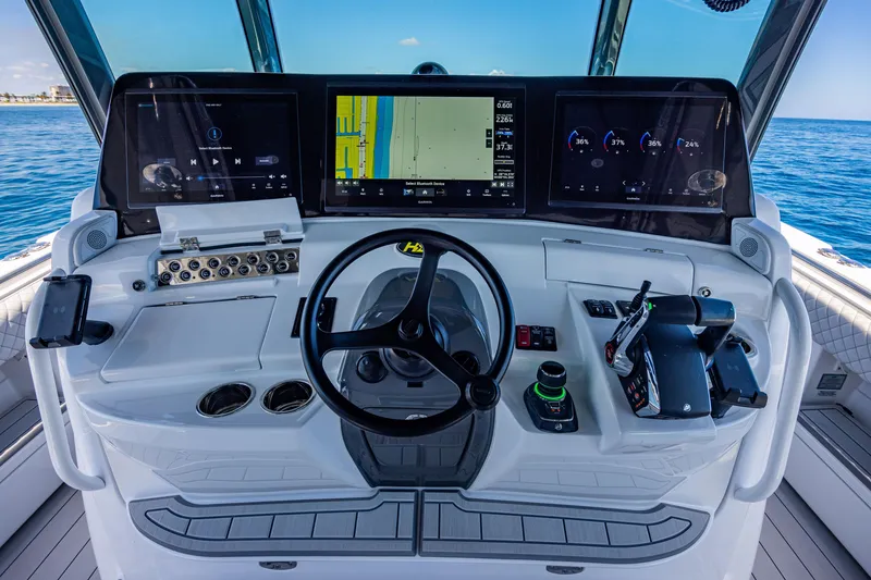 Slide: The Image of 2024 HCB 53 Suenos helm with advanced navigation displays and controls on open water. - 15