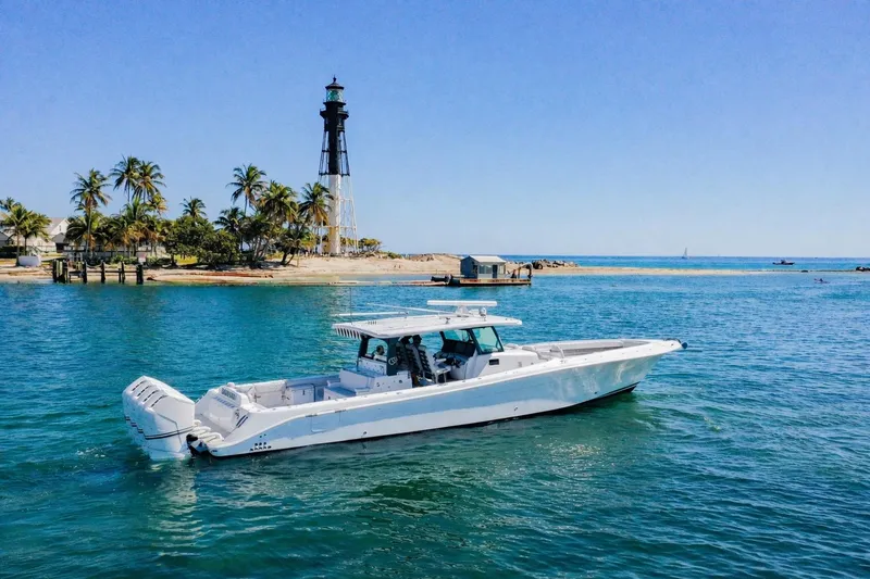 Slide: The Image of 2024 HCB 53 Suenos boat cruising near a lighthouse and palm trees. - 2