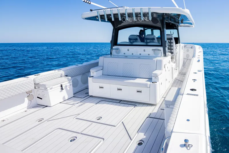 Slide: The Image of 2024 HCB 53 Suenos luxury boat on open sea, featuring spacious deck and seating. - 8