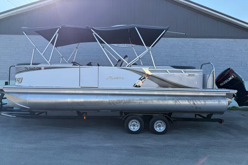 The Image of 2024 Avalon LSZ Quad Lounge 25' pontoon boat with Suzuki outboard motor on trailer. - 0