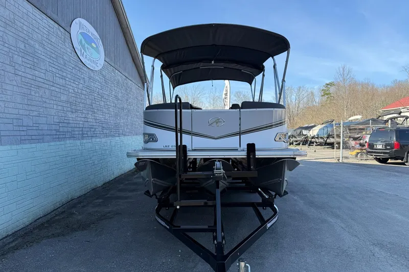 Slide: The Image of 2024 Avalon LSZ Quad Lounge 25' pontoon boat on trailer at dealership. - 2