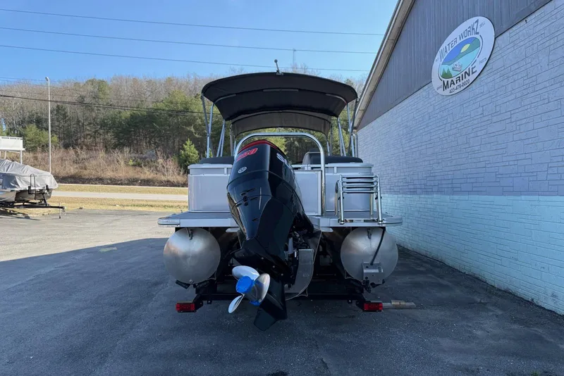 Slide: The Image of 2024 Avalon LSZ Quad Lounge 25' pontoon boat with outboard motor, parked at marina. - 4