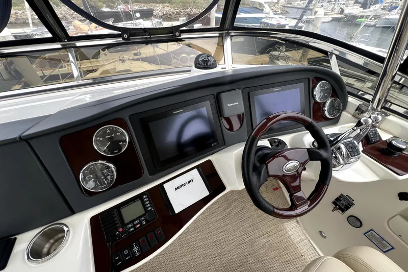 Slide: The Image of 2013 Meridian 441 Sedan helm with modern navigation displays and controls at a marina. - 14
