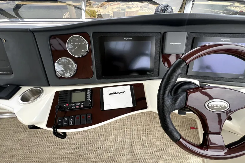 Slide: The Image of 2013 Meridian 441 Sedan yacht dashboard with Raymarine displays and Mercury controls. - 15