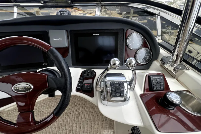 Slide: The Image of 2013 Meridian 441 Sedan yacht helm with steering wheel, controls, and navigation displays. - 16