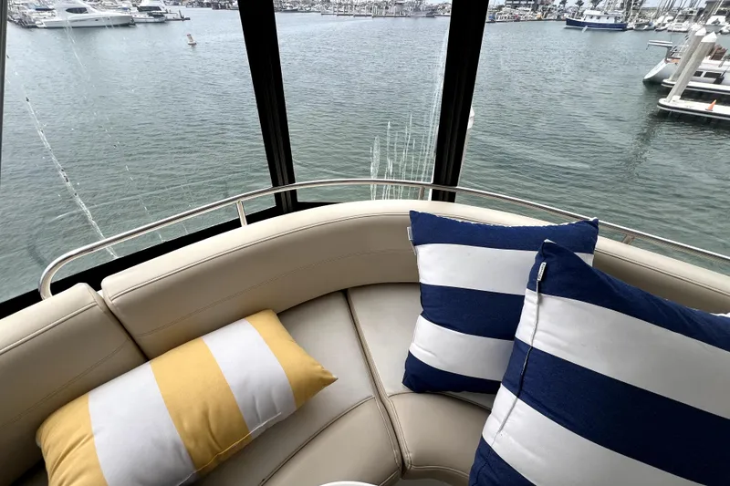 Slide: The Image of Interior view of 2013 Meridian 441 Sedan yacht with striped cushions and marina backdrop. - 21