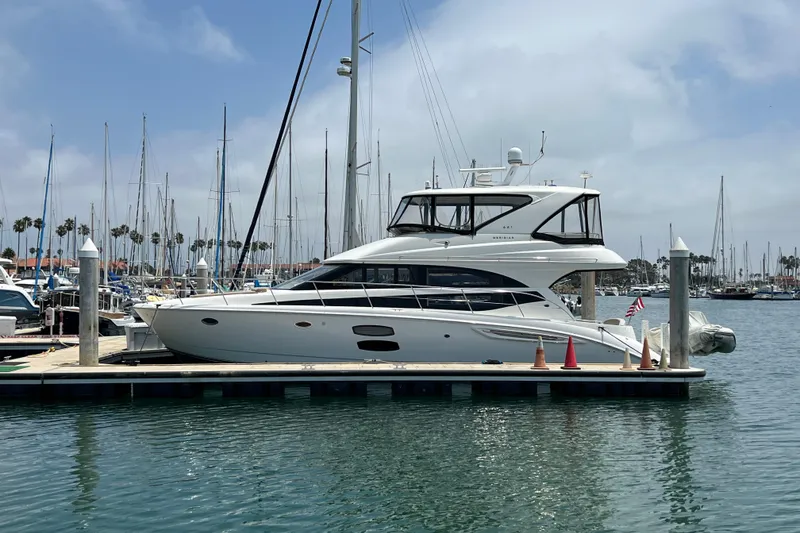 Slide: The Image of 2013 Meridian 441 Sedan yacht docked at a marina with sailboats in the background. - 3