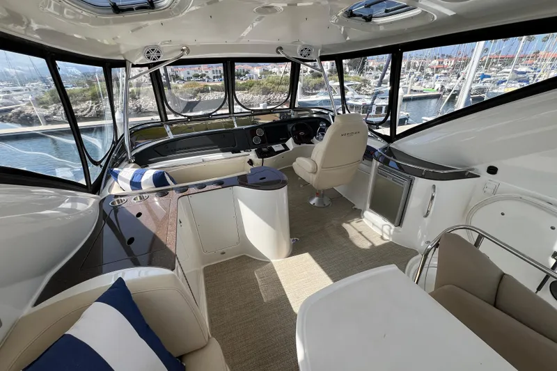 Slide: The Image of Interior of 2013 Meridian 441 Sedan yacht with helm, seating, and marina view. - 9