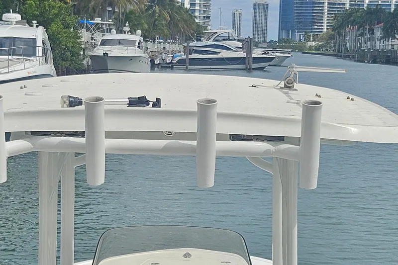 Slide: The Image of 2016 Sportsman Heritage 211 Center Console boat docked in a marina with cityscape background. - 16