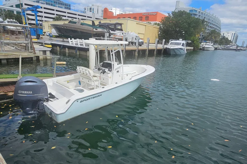 Slide: The Image of 2016 Sportsman Heritage 211 Center Console boat docked in a marina with Yamaha engine. - 2