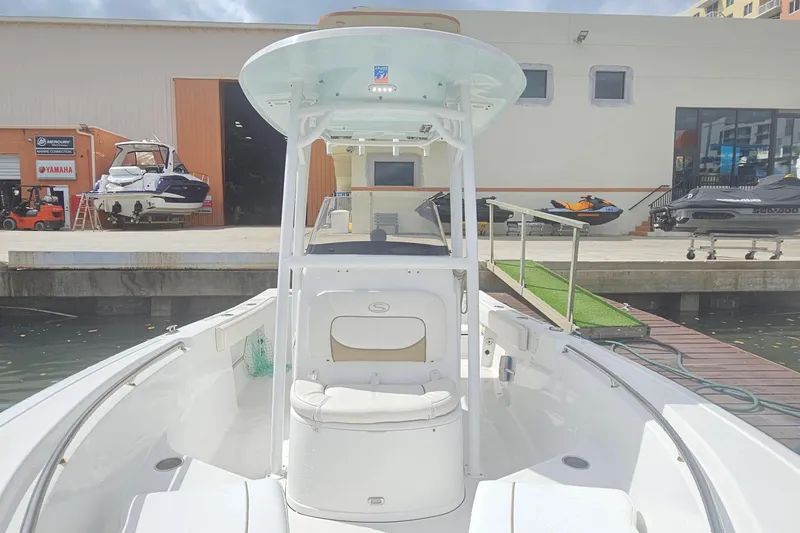 Slide: The Image of 2016 Sportsman Heritage 211 Center Console boat docked near a marina workshop. - 4