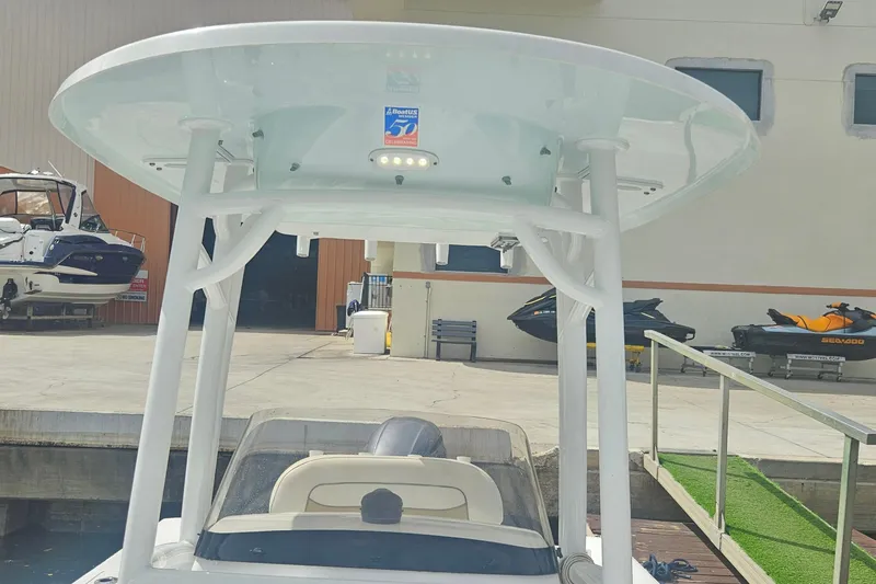 Slide: The Image of 2016 Sportsman Heritage 211 Center Console boat at a marina with jet skis in the background. - 5