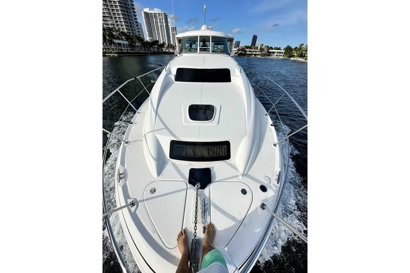 Slide: The Image of 2003 Sea Ray 390 Motor Yacht cruising on a sunny day, with cityscape in background. - 3