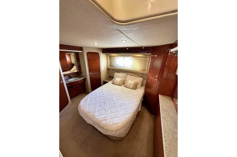 Slide: The Image of Luxurious bedroom interior of 2003 Sea Ray 390 Motor Yacht with elegant wood finishes. - 9
