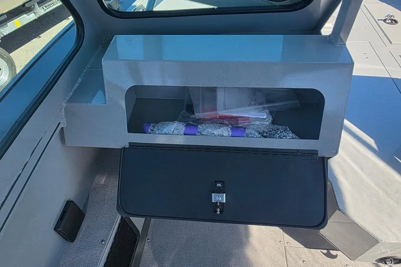 Slide: The Image of 2026 Smoker Craft Avenger 188 HD Pro interior storage compartment with open lid. - 18