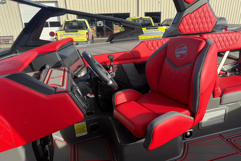 Slide: The Image of 2026 Tigé 24RZX boat interior with red and gray seating, modern dashboard, and steering wheel. - 18