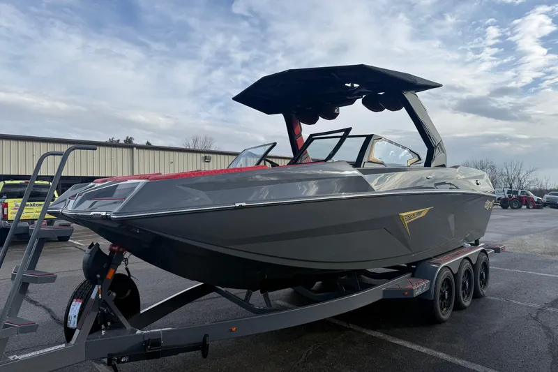 Slide: The Image of 2026 Tigé 24RZX boat on trailer, sleek design, parked outdoors under cloudy sky. - 3