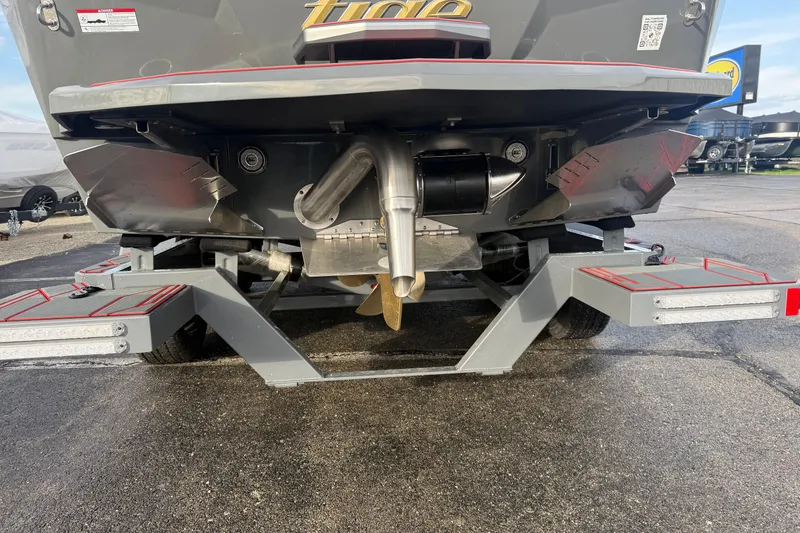 Slide: The Image of Rear view of a 2026 Tigé 24RZX boat on a trailer, showcasing the propeller and exhaust system. - 9
