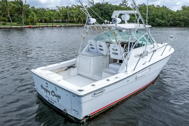 Slide: The Image of 2000 Rampage 30 Express boat on water, featuring spacious deck and fishing equipment. - 10