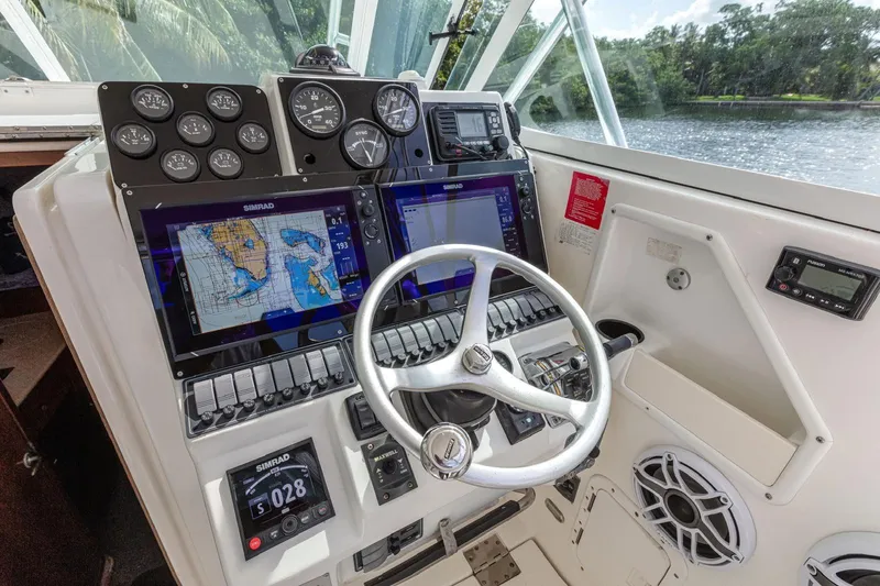 Slide: The Image of Cockpit of 2000 Rampage 30 Express boat with navigation screens and steering wheel. - 12