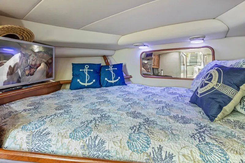 Slide: The Image of Cozy cabin interior of 2000 Rampage 30 Express with nautical-themed bedding and decor. - 13