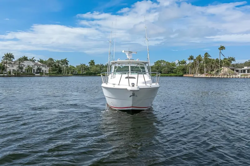 Slide: The Image of 2000 Rampage 30 Express boat on calm water with palm trees and blue sky. - 3